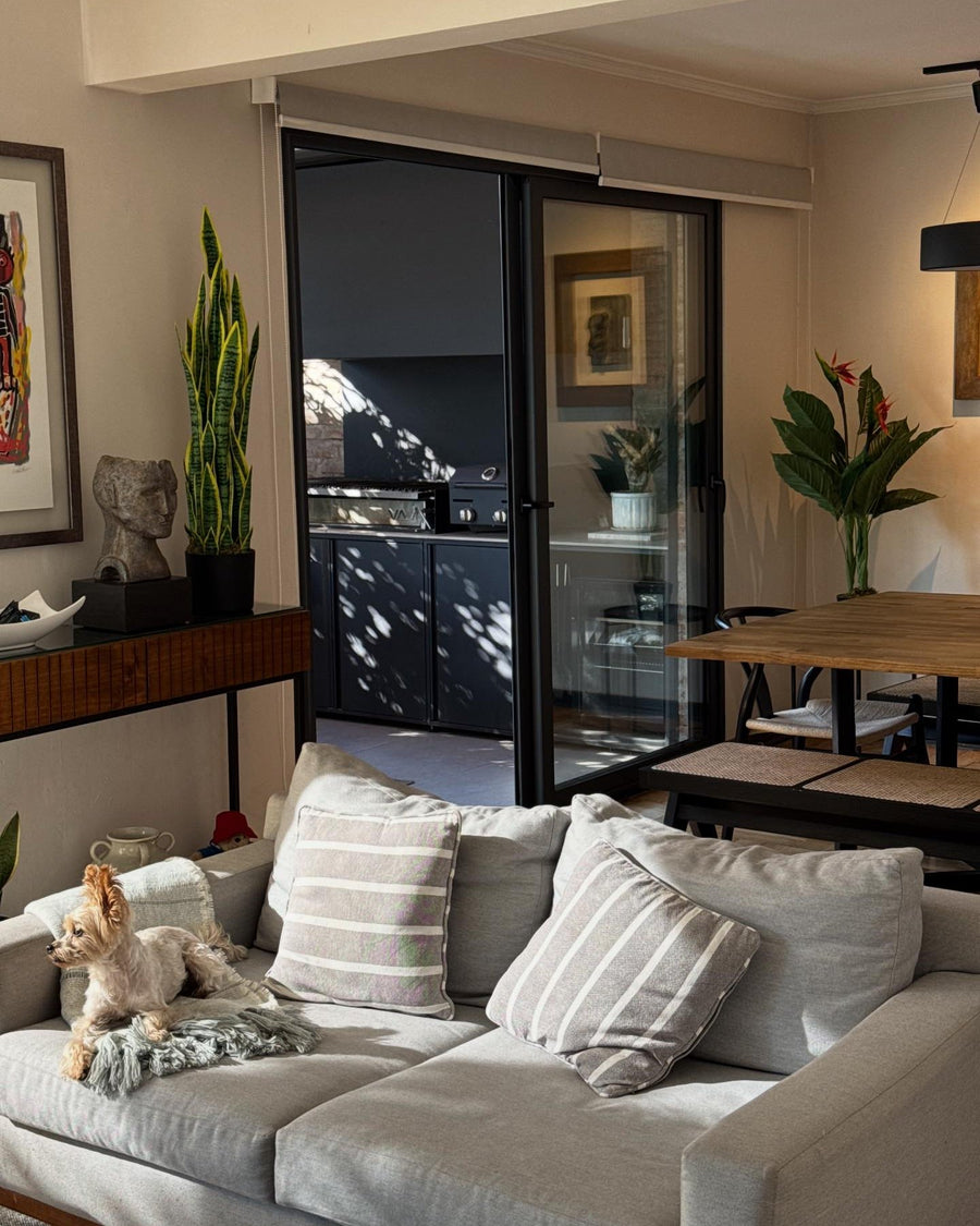 Living con plantas artificiales y sofá gris - Magno Botanics
